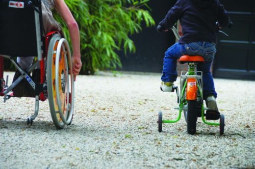 rolstoel en kinderfiets op grindpad